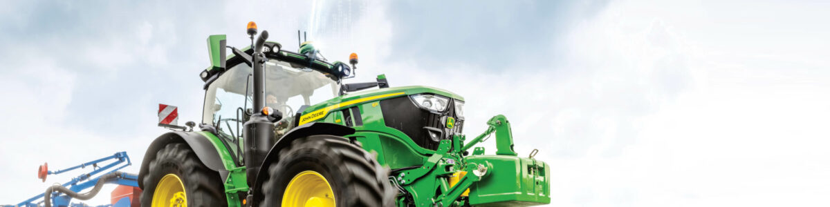 John Deere Traktor vor blauem Himmel